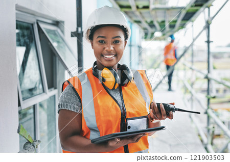 Portrait of proud black construction worker leading with power while managing site logistics on tablet. Happy female engineer supervising a building project and inspection of architectural details 121903503