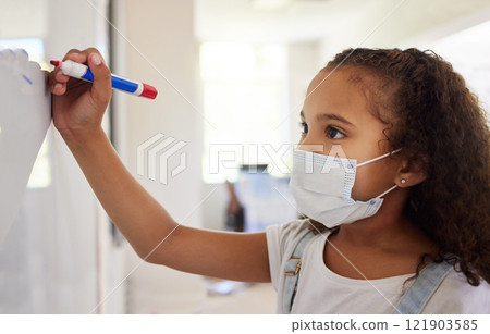 School student writing on whiteboard in class during covid pandemic for learning, education and study. Young kindergarten, preschool or elementary kid with mask for safety, protection and protocol School student writing on whiteboard in class during covid pandemic for learning, education and study. Young kindergarten, preschool or elementary kid with mask for safety, protection and protocol 121903585