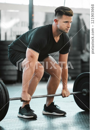 Fit, active and strong man with barbell weight for lifting in gym workout, exercise and training. Serious, motivated and sporty athlete building muscle, cardio health and endurance in wellness centre 121903668