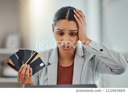 Finance, debt and credit with a business woman suffering from worry, stress and anxiety of inflation in the economy. Young female holding bank cards and having problems while trying to pay an account 121903669