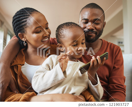 Happy, bonding and family time with a black family on a video call. Young parents being affectionate with their baby while streaming and watching something on a phone, enjoying time with their son 121903727