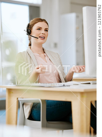 Insurance agent, call center or contact support employee giving good customer service via her headset at her help desk at work. Female advisor consulting and helping via her headset talking about us 121903762