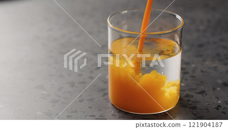 sea buckthorn juice pour into beaker glass with water on concrete surface 121904187