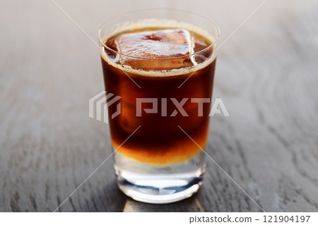 Espresso tonic with clear ice cube in tumbler glass on oak wood table with copy space Espresso tonic with clear ice cube in tumbler glass on oak wood table with copy space 121904197