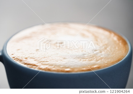 Fresh cappuccino in blue cup closeup 121904264