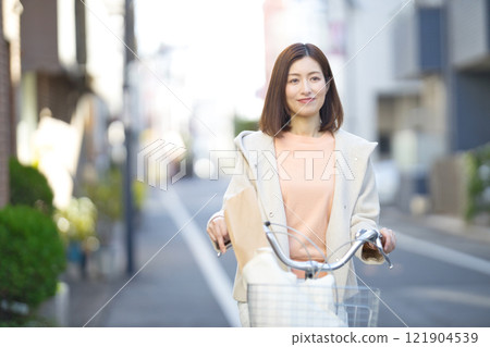 Middle-aged woman going shopping by bicycle Middle-aged woman going shopping by bicycle 121904539