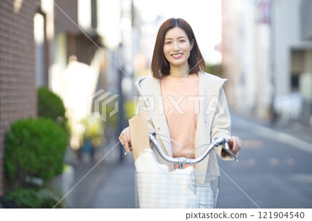 Middle-aged woman going shopping by bicycle Middle-aged woman going shopping by bicycle 121904540