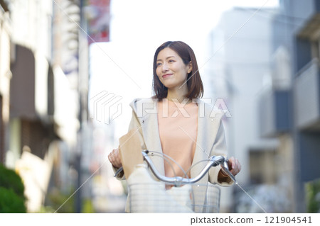 Middle-aged woman going shopping by bicycle Middle-aged woman going shopping by bicycle 121904541