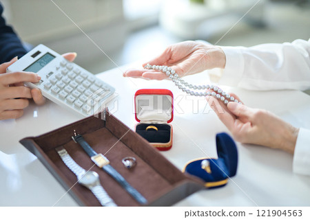 一位採購專家和一位中年婦女正在評估貴金屬 121904563