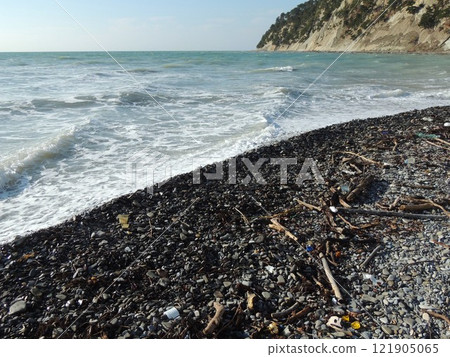 small household and natural garbage on the rocky coast of the Black Sea, an empty rocky beach with plastic waste and seaweed washed ashore after a storm, the problem of water pollution small household and natural garbage on the rocky coast of the Black Sea, an empty rocky beach with plastic waste and seaweed washed ashore after a storm, the problem of water pollution 121905065