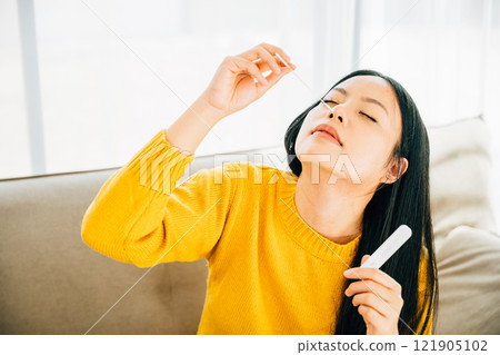 Depicting COVID-19 self-testing, Asian woman uses a rapid antigen test kit at home inserting a swab into her nose. Emphasizing virus prevention and pandemic protection measures. Depicting COVID-19 self-testing, Asian woman uses a rapid antigen test kit at home inserting a swab into her nose. Emphasizing virus prevention and pandemic protection measures. 121905102