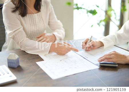 簽署房地產合約的兩名婦女的手 121905139