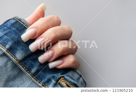 Woman hand with stylish french manicure holding denim jacket, fashion and beauty trends 121905210