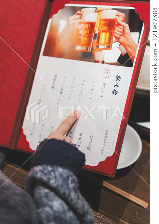 A female customer looks at the menu and makes a selection [Photo courtesy of Seafood Izakaya Gyoruko] 121907383