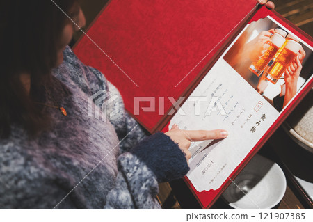 女顧客看著菜單並做出選擇的手[照片提供：海鮮居酒屋Uoroko] 121907385