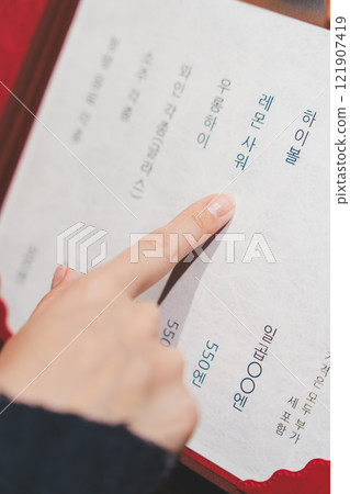 女顧客看著菜單並做出選擇的手[照片提供：海鮮居酒屋Uoroko] 121907419