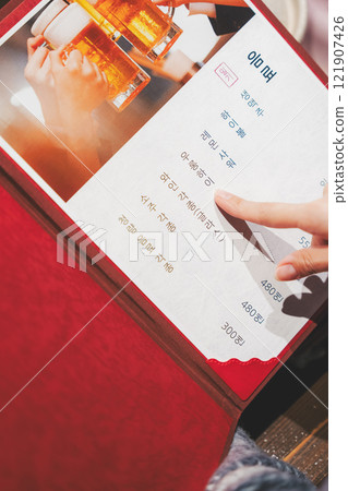 A female customer looks at the menu and makes a selection [Photo courtesy of Seafood Izakaya Gyoruko] 121907426