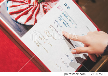 女顧客看著菜單並做出選擇的手[照片提供：海鮮居酒屋Uoroko] 121907518