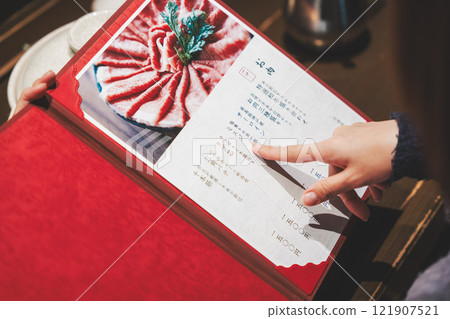 女顧客看著菜單並做出選擇的手[照片提供：海鮮居酒屋Uoroko] 121907521