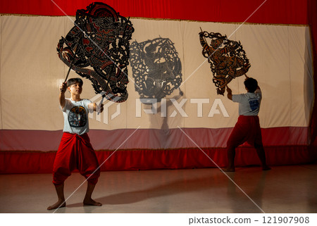 Asian young men show or perform grand shadow play together to present Thai culture and traditional performance for tourist and the other people and conservation good culture. 121907908