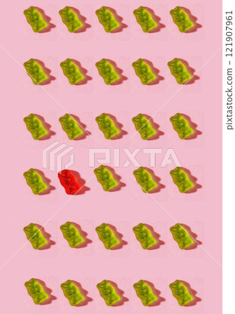 A design featuring gummies arranged on a pink background to represent the only red person 121907961