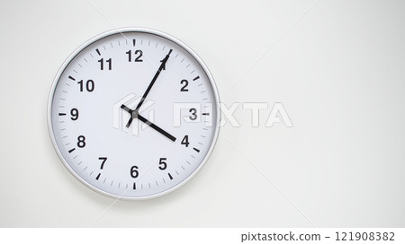 Minimalist White Clock with Silver Frame Striking 16.05/04.05 on White Background. Perfect for Time Management and Corporate Campaigns Minimalist White Clock with Silver Frame Striking 16.05/04.05 on White Background. Perfect for Time Management and Corporate Campaigns 121908382