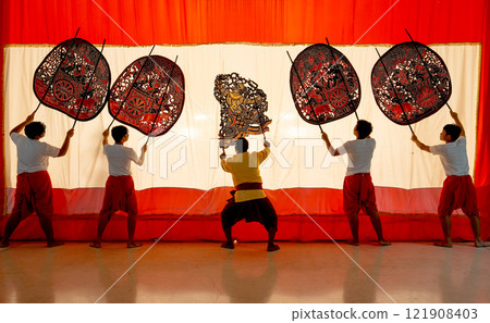 Five player men stand with perform grand shadow play in front of white screen with action as performance of the show. 121908403