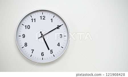 Minimalist White Clock with Silver Frame Striking 17.10/05.10 on White Background. Perfect for Time Management and Corporate Campaigns Minimalist White Clock with Silver Frame Striking 17.10/05.10 on White Background. Perfect for Time Management and Corporate Campaigns 121908428
