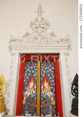The red chapel door is eye-catching with a picture of the goddess wearing a Thai crown Represents contemporary Thai culture at Wat Naga Plok temple. The red chapel door is eye-catching with a picture of the goddess wearing a Thai crown Represents contemporary Thai culture at Wat Naga Plok temple. 121908692