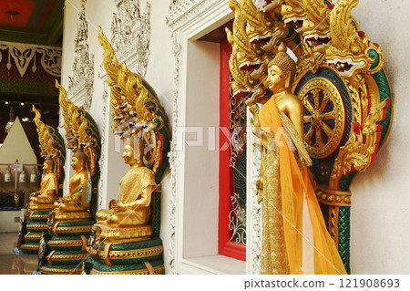 A group of Buddha statues in various postures with a serpent covering the top. Decorated around the chapel at Wat Naga Prok Temple. Located at Bangkok capital city in Thailand. 121908693