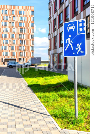 Road sign Residential zone with apartment building and yard on background. Pedestrian priority area. Begin Yard area Road sign Residential zone with apartment building and yard on background. Pedestrian priority area. Begin Yard area 121908713