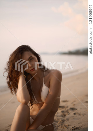 Beautiful model in sand on the beach. Sexy girl in Bikini 121908945