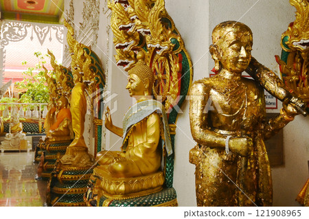 A group of Buddha statues in various postures with a serpent covering the top. Decorated around the chapel at Wat Naga Prok Temple. Located at Bangkok capital city in Thailand. 121908965