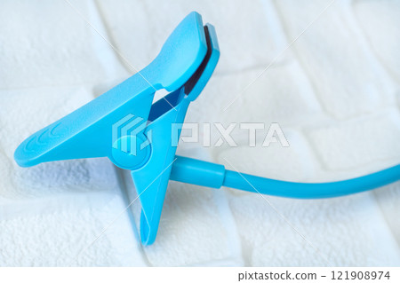 Blue flexible holder with a clamp for a phone, something 121908974