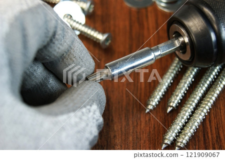 Removing the Torx bit from the adapter. Work process of the builder. 121909067