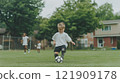 Child with prosthetic leg brings joy to soccer game in neighborhood park with friends enjoying the sunny afternoon 121909178