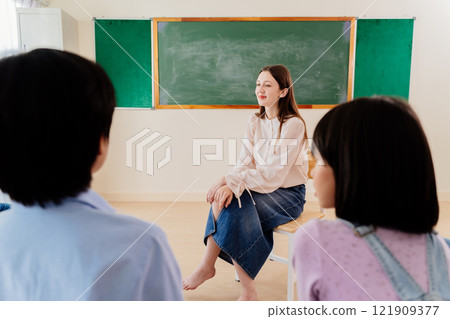 Friendly Teacher Facilitates Interactive Learning Circle with Young Pupils, Nurturing Communication Skills in School 121909377