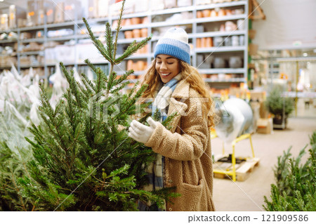 A woman in a blue hat chooses to celebrate Christmas at a fair. Holiday concept. Lifestyle. A woman in a blue hat chooses to celebrate Christmas at a fair. Holiday concept. Lifestyle. 121909586