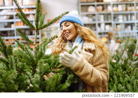 A woman in a blue hat chooses to celebrate Christmas at a fair. Holiday concept. Lifestyle. 121909587