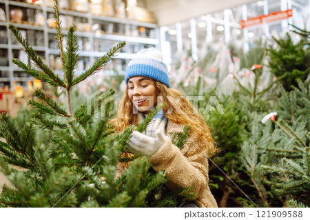 A woman in a blue hat chooses to celebrate Christmas at a fair. Holiday concept. Lifestyle. 121909588