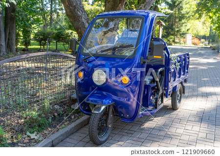 Three wheels motorcycle with cabin. Blue car with trailer for one Three wheels motorcycle with cabin. Blue car with trailer for one 121909660