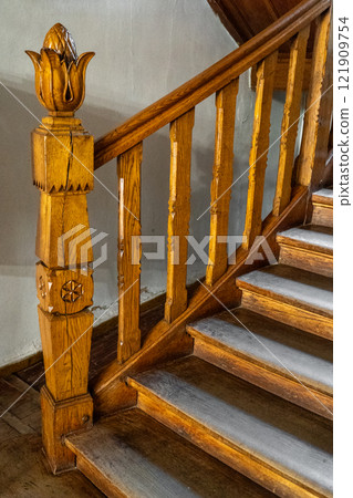 Wooden railings on the stairs. Wood carving. Artichoke in the interior and architecture. 121909754