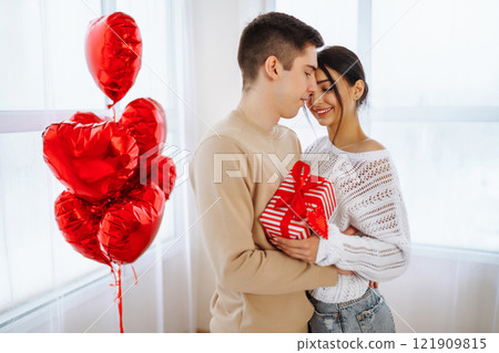 Exchange of gifts. Romantic day together. Valentines day, couple, relationships and people concept. Exchange of gifts. Romantic day together. Valentines day, couple, relationships and people concept. 121909815