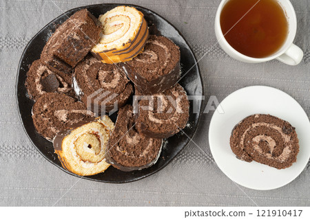Chocolate Swiss Roll, Round Sponge Cake, Sliced Rolled Vanilla Biscuit with Cocoa Cream Filling Chocolate Swiss Roll, Round Sponge Cake, Sliced Rolled Vanilla Biscuit with Cocoa Cream Filling 121910417
