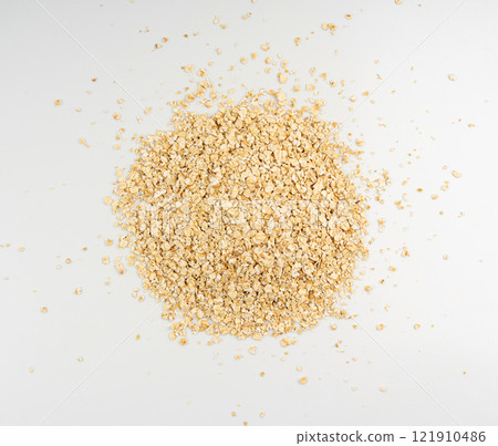 Dry raw oat flakes isolated, rolled flat grains, instant porridge, thin cereals, flattened grains group 121910486