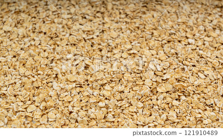 Dry raw oat flakes texture background, rolled flat grains pattern, instant porridge mockup, thin cereals 121910489