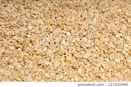 Dry raw oat flakes texture background, rolled flat grains pattern, instant porridge mockup, thin cereals 121910490