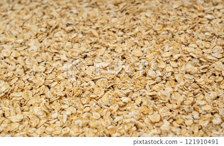 Dry raw oat flakes texture background, rolled flat grains pattern, instant porridge mockup, thin cereals 121910491