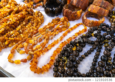 Amber stones market, polished orange gemstones closeup, natural Baltic amber gems jewelry store Amber stones market, polished orange gemstones closeup, natural Baltic amber gems jewelry store 121910536
