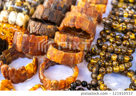 Amber stones market, polished orange gemstones closeup, natural Baltic amber gems jewelry store Amber stones market, polished orange gemstones closeup, natural Baltic amber gems jewelry store 121910537